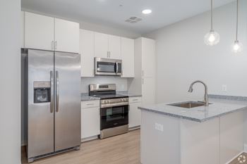 A modern kitchen with stainless steel appliances and white cabinets. at Park Lamont Townhomes Apartments, Ohio